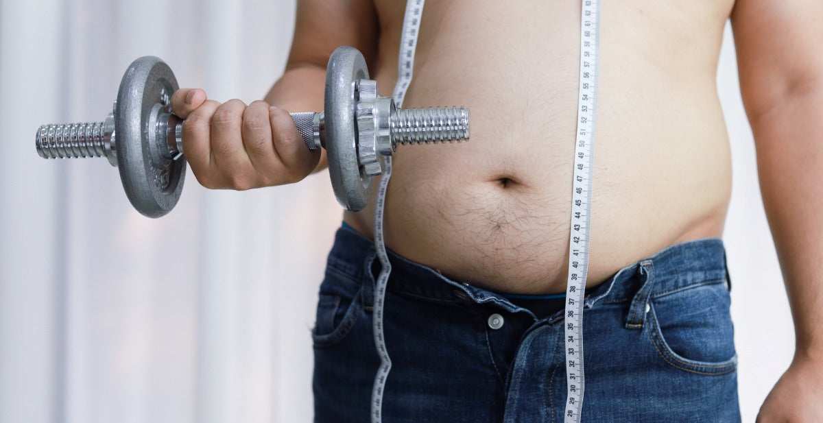 Overweight man exercising by lifting weight with a dumbbell